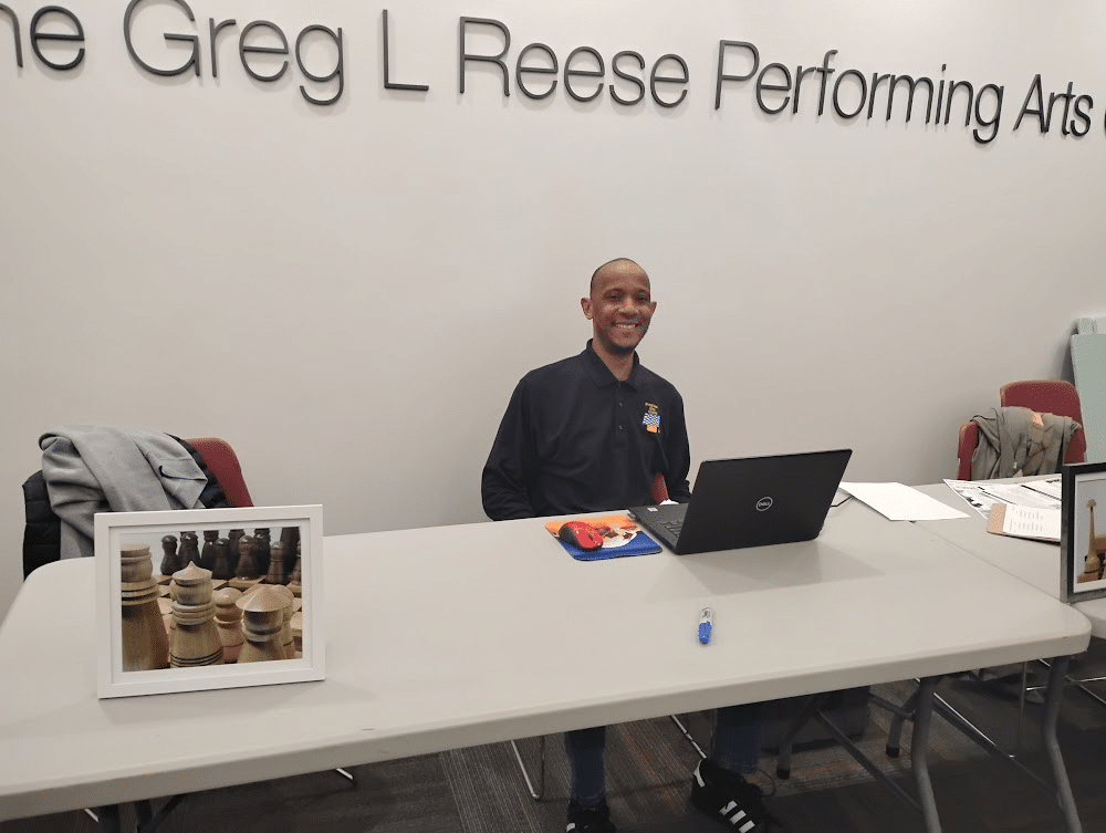 Roy-Allen Bumpers smiles as he checks players into the 3rd East Side Open Chess Tournament