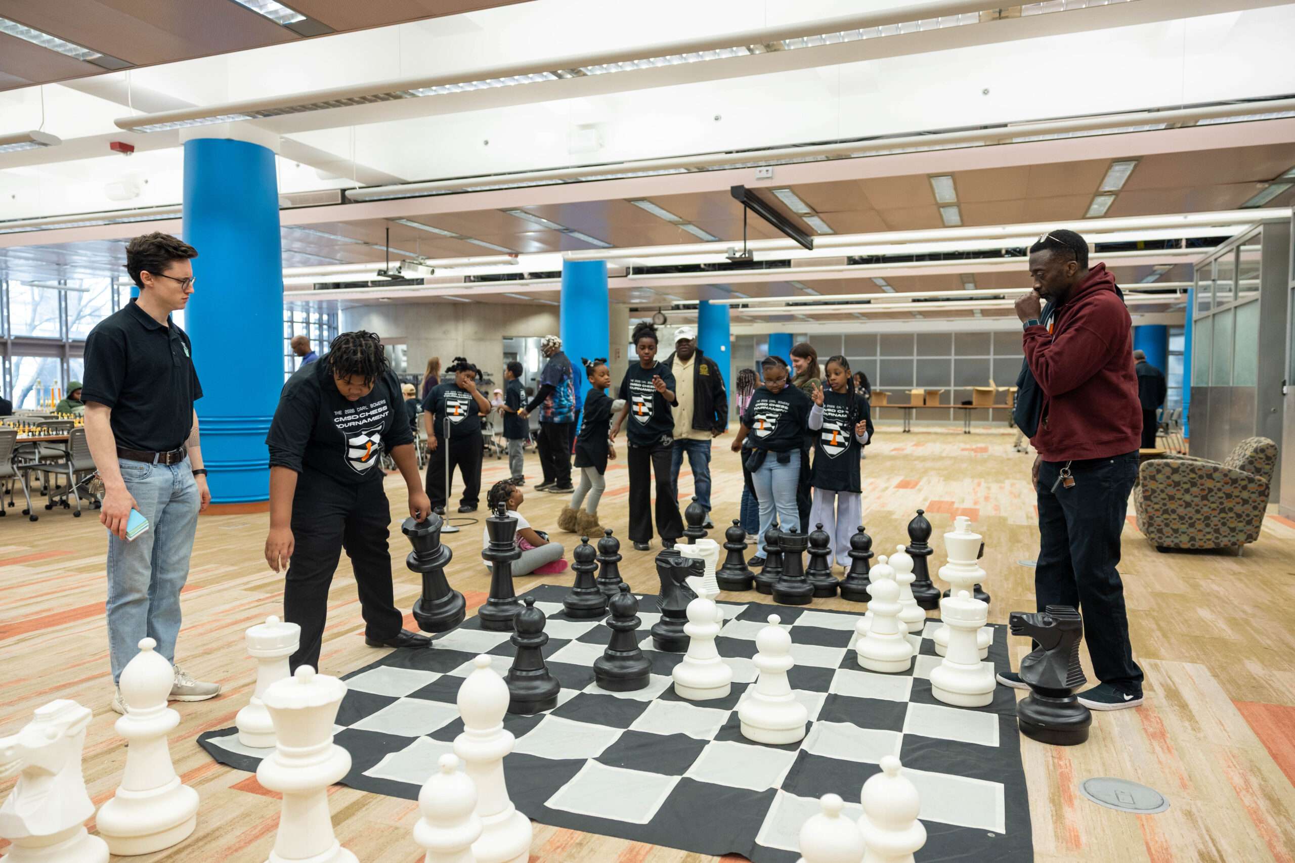 HARVEY RICE STUDENTS PLAY GIANT CHESS WITH PWC COACHES AT THE DOWNTOWN LIBRARY